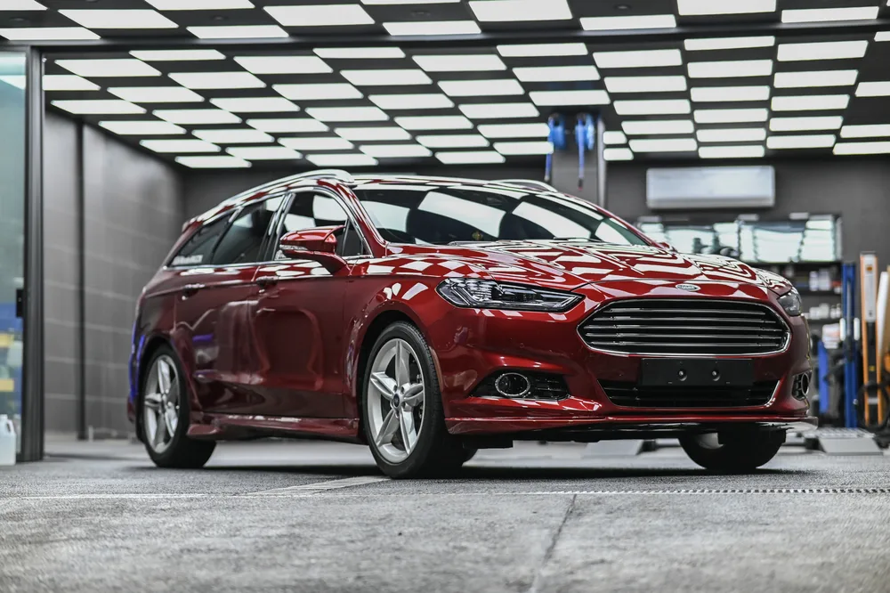Ford Mondeo Wagon 紅色旅行車完成全車透明保護膜包覆後停於廠內,車身側面映出天花板棋盤格燈條|誠美車體美容