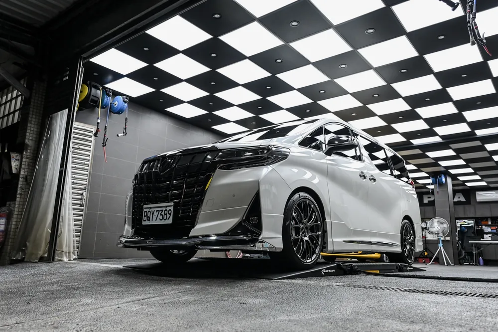 清洗完成的白色 Toyota Alphard 停在施工區,車頭與側裙保持乾淨,誠美車體美容