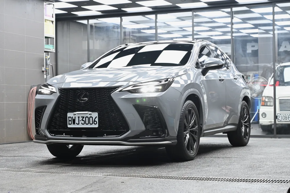 Lexus NX 350 淺灰車身在廠內完成膜料維護後的車頭四分之三視角,車頂棋盤格燈條完整映在引擎蓋上|誠美車體美容