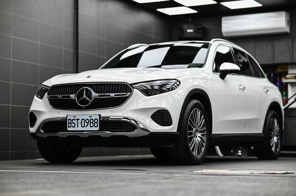 白色 Mercedes-Benz GLC 完成雙層鍍膜後停於施工棚內,右前四十五度全車呈現鏡面光澤,誠美車體美容