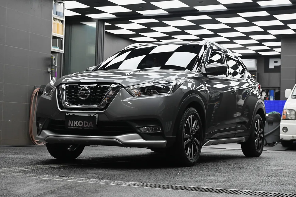 深灰色 Nissan Kicks 完成日本 3D 滑水精緻護理後停於格紋施工區,右前方全景,誠美車體美容