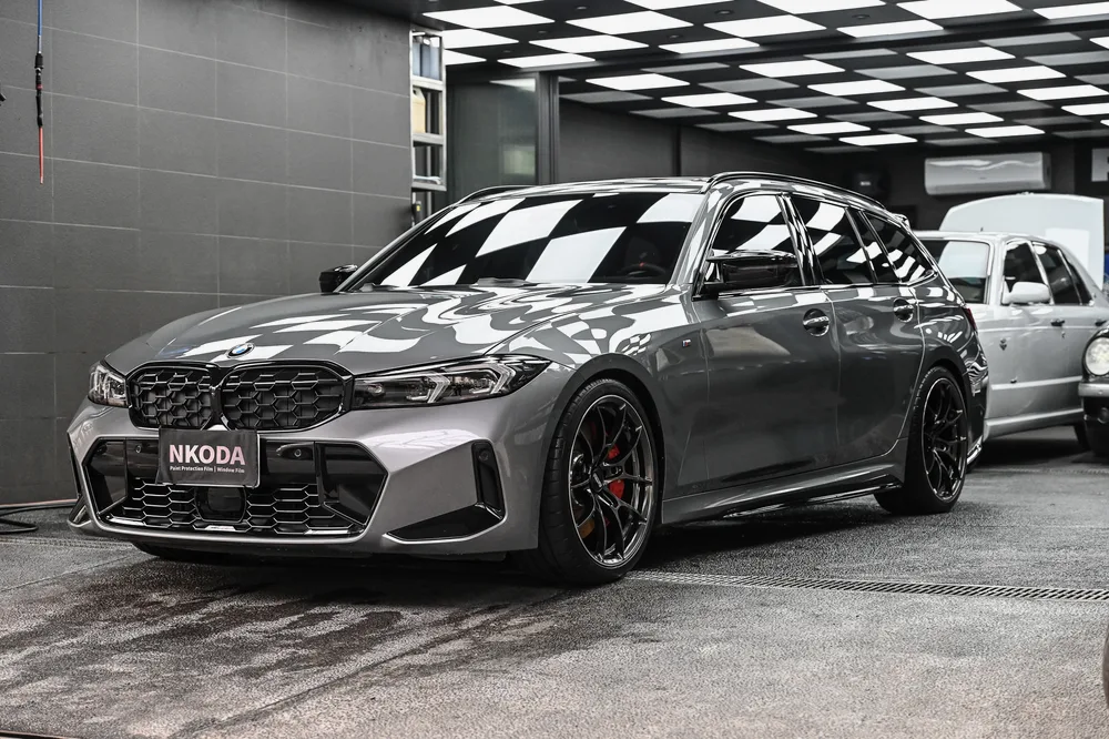 灰色 BMW M3 Touring 完成日本 3D 滑水精緻護理後停於格紋施工區,左前方全景,誠美車體美容
